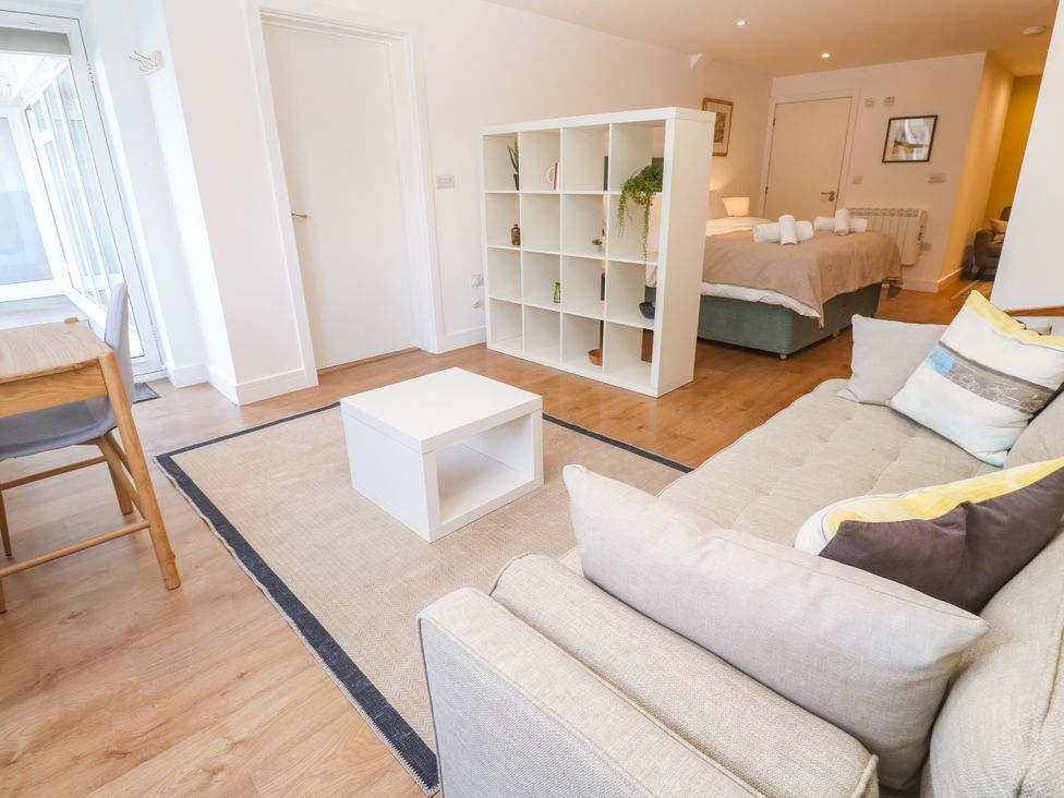 A living room with a sofa and coffee table at 11 Fountain Court in Falmouth