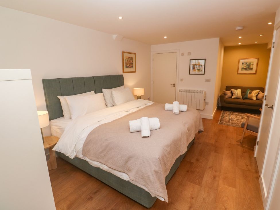 A bedroom with a bed and sofa at 11 Fountain Court in Falmouth
