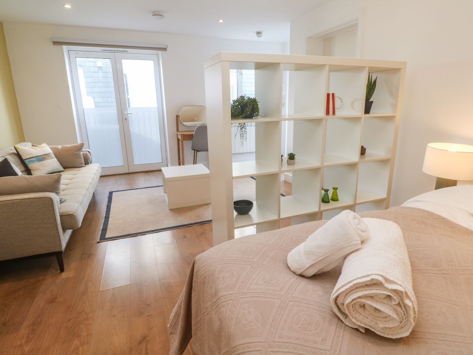 A living room with a shelf and sofa at 11 Fountain Court in Falmouth