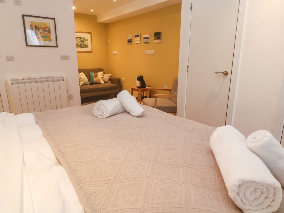 A bedroom with a bed and towels at 11 Fountain Court in Falmouth