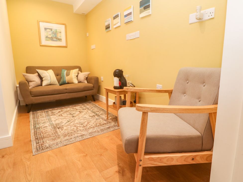 A living room with a sofa and chair at 11 Fountain Court in Falmouth