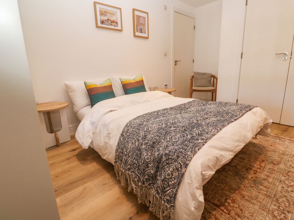 A bedroom with a bed and cushions at 11 Fountain Court in Falmouth