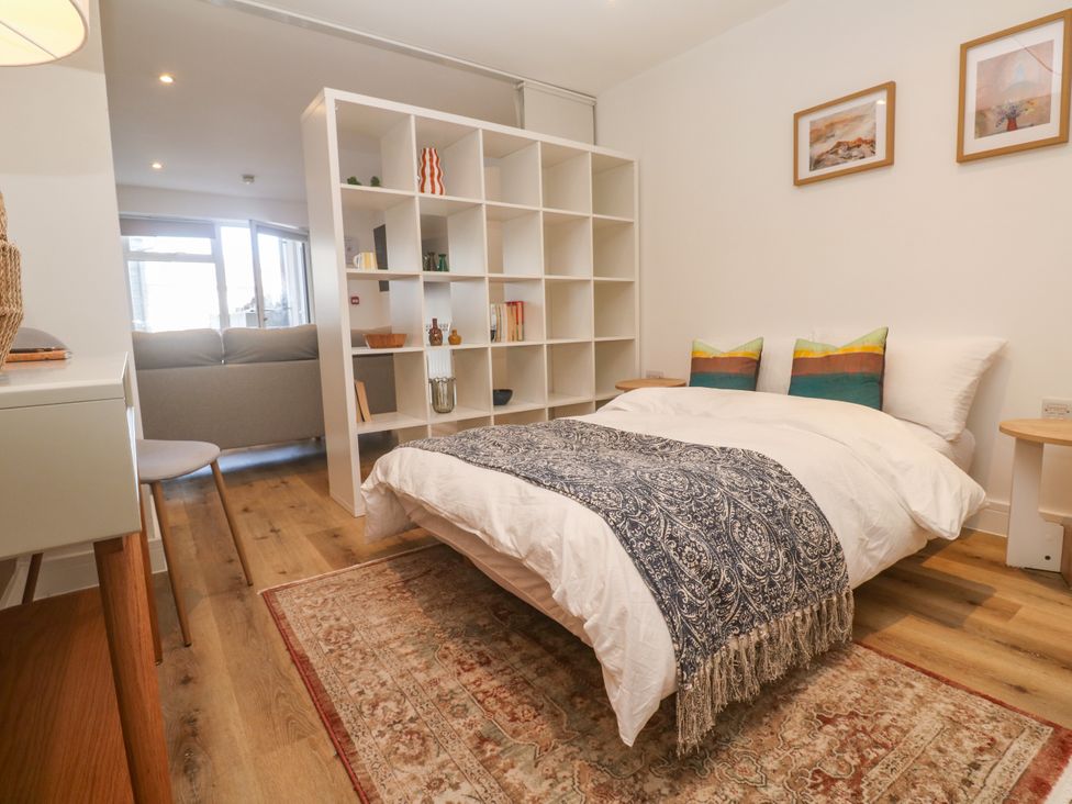 A bedroom with a bed and shelves at 11 Fountain Court in Falmouth