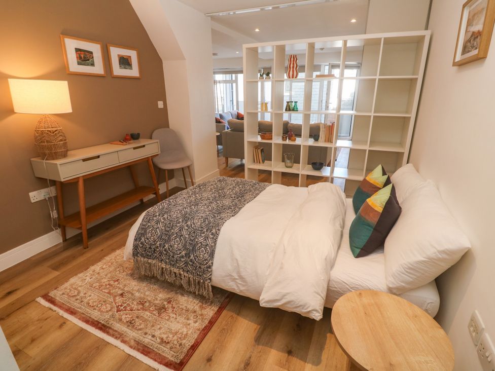 A bedroom with a bed and side table at 11 Fountain Court in Falmouth