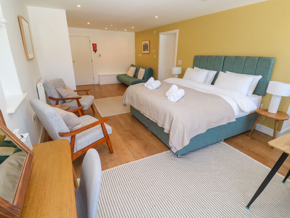 A bedroom with a bed and seating area at 11 Fountain Court in Falmouth