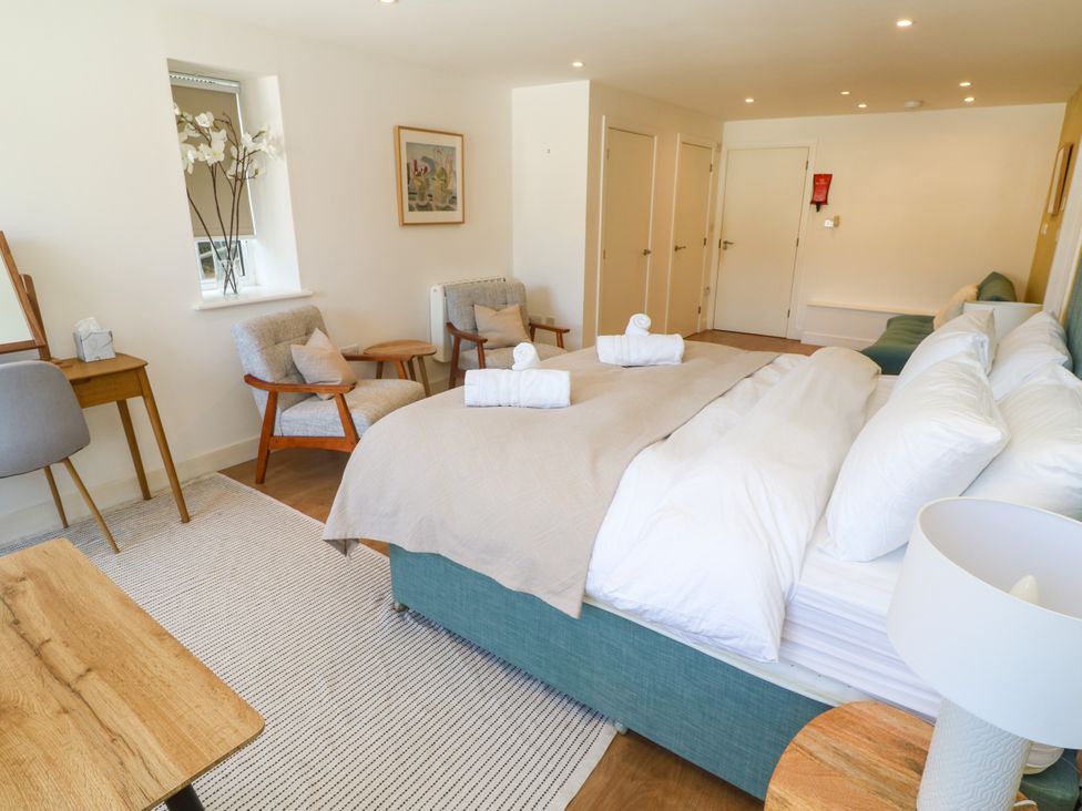 A bedroom with a bed and seating area at 11 Fountain Court in Falmouth