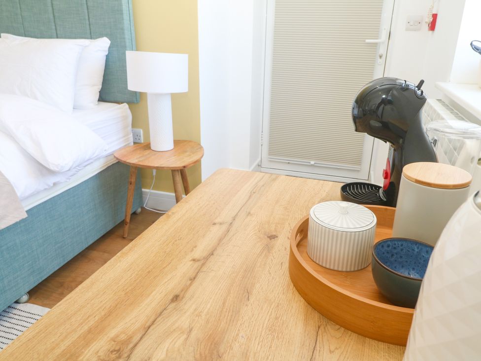 A bedroom with a bed and a coffee maker on a table at 11 Fountain Court in Falmouth