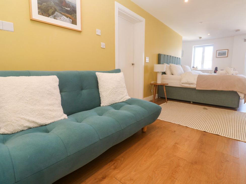 A bedroom with a sofa and bed at 11 Fountain Court in Falmouth