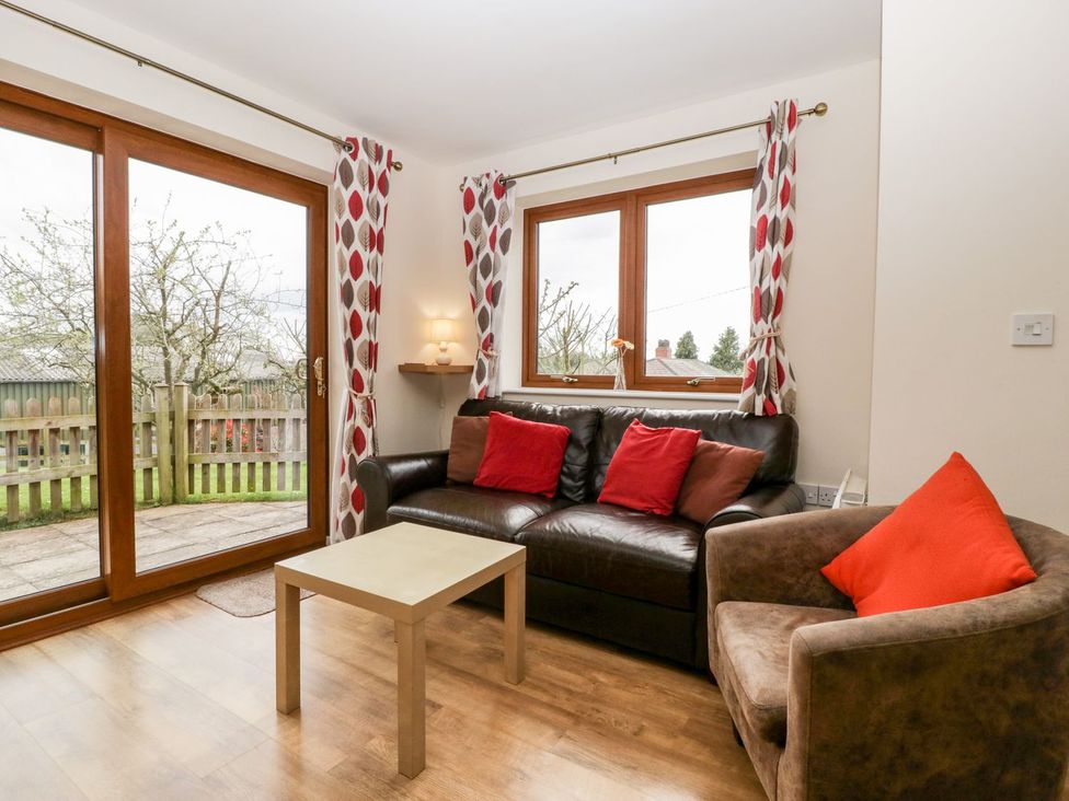 A living room with a sofa and a coffee table at Orchard Cottage in Ledbury