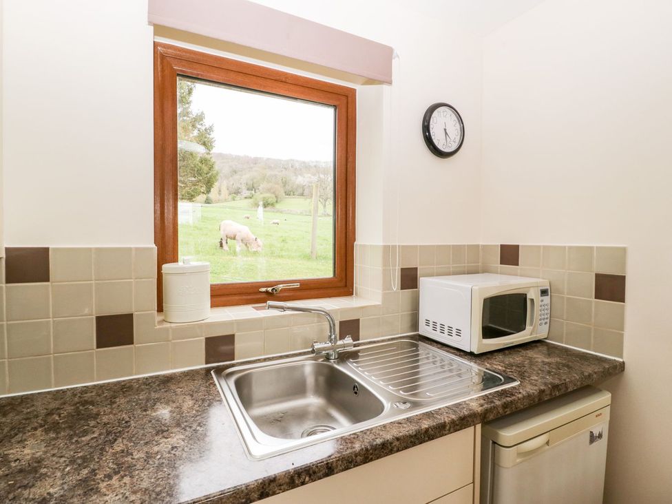 A kitchen with a sink and microwave at Orchard Cottage in Ledbury