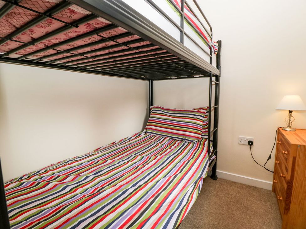 A bedroom with a bunk bed and striped bedding at Orchard Cottage in Ledbury