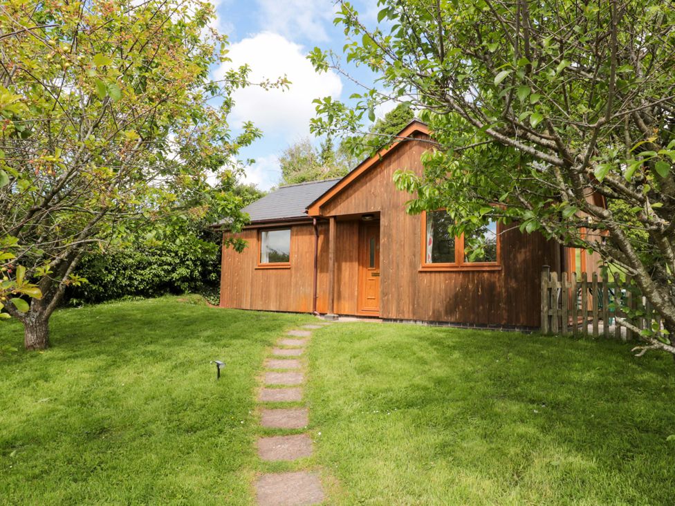 A cottage surrounded by grass and trees at Orchard Cottage in Ledbury