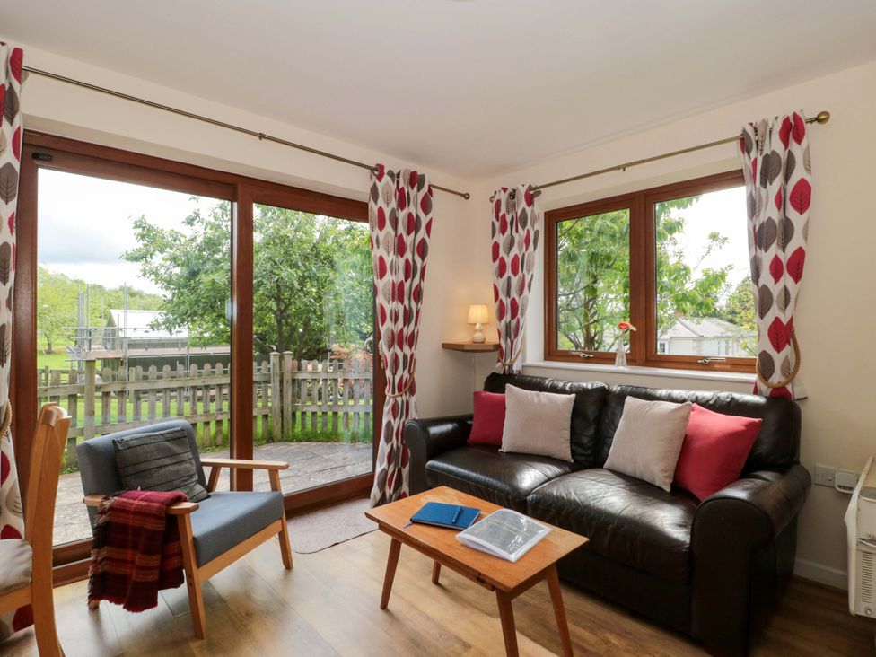 A living room with a sofa and armchair at Orchard Cottage in Ledbury