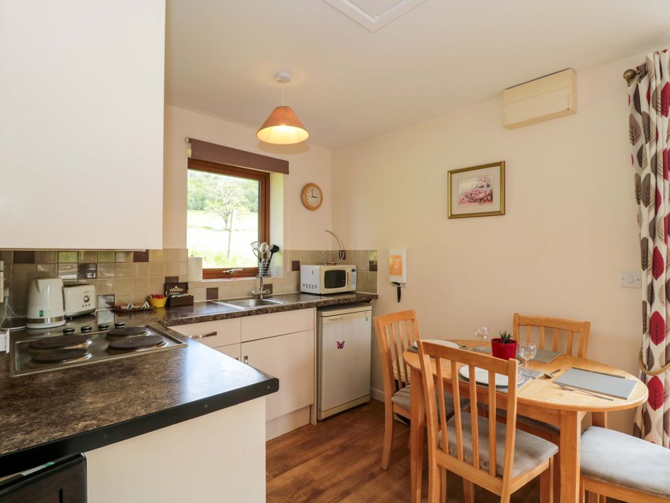 A kitchen with a dining table and stove at Orchard Cottage in Ledbury