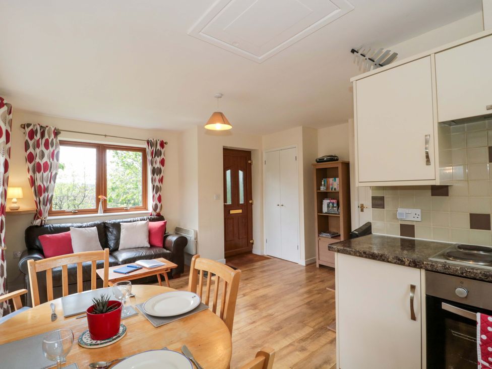A living room with a sofa and dining table at Orchard Cottage in Ledbury