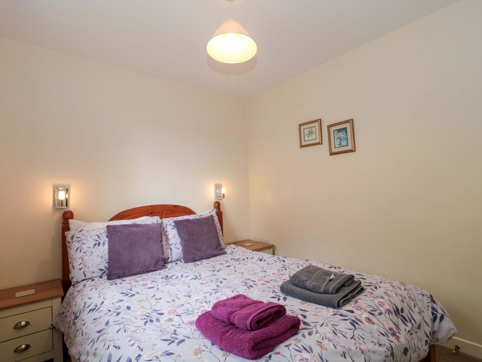A bedroom with a bed and bedside table at Orchard Cottage in Ledbury