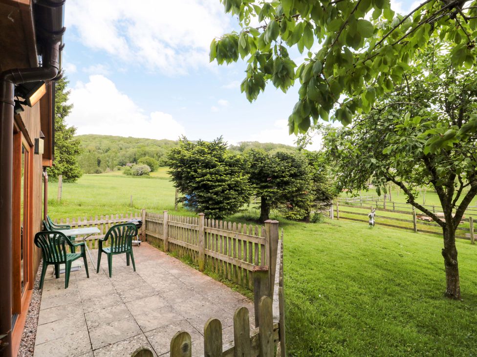 A garden area with a table and chairs outside Orchard Cottage in Ledbury