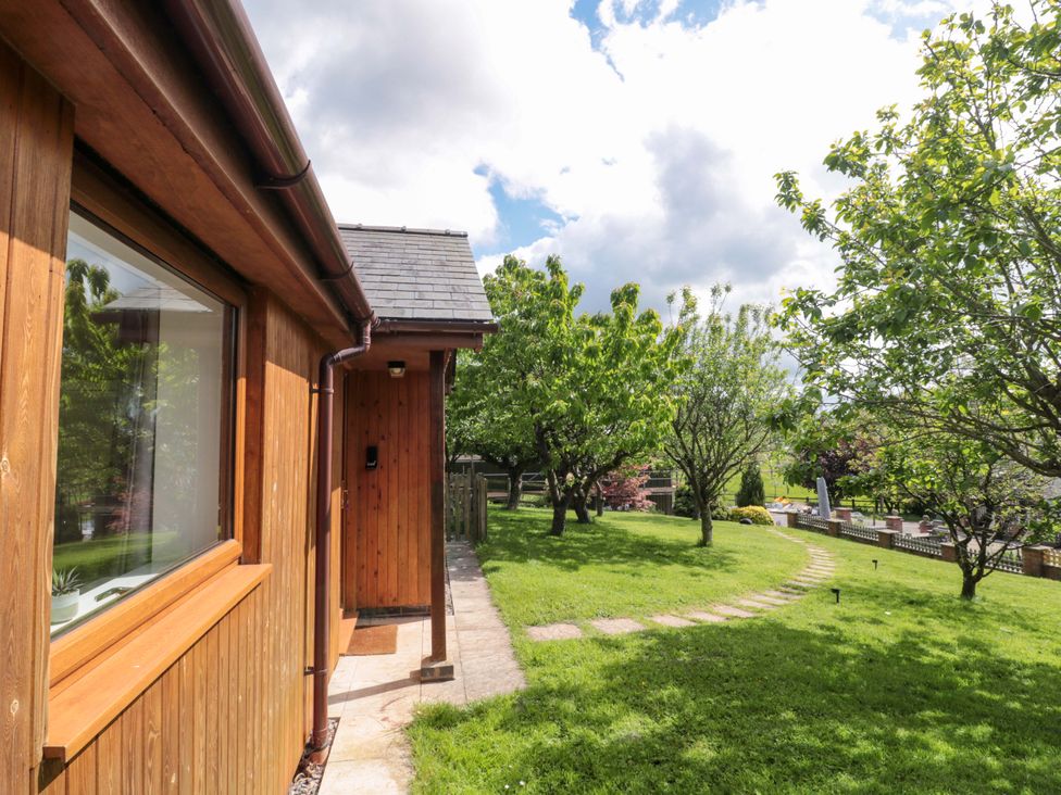 A garden with trees and a pathway at Orchard Cottage in Ledbury