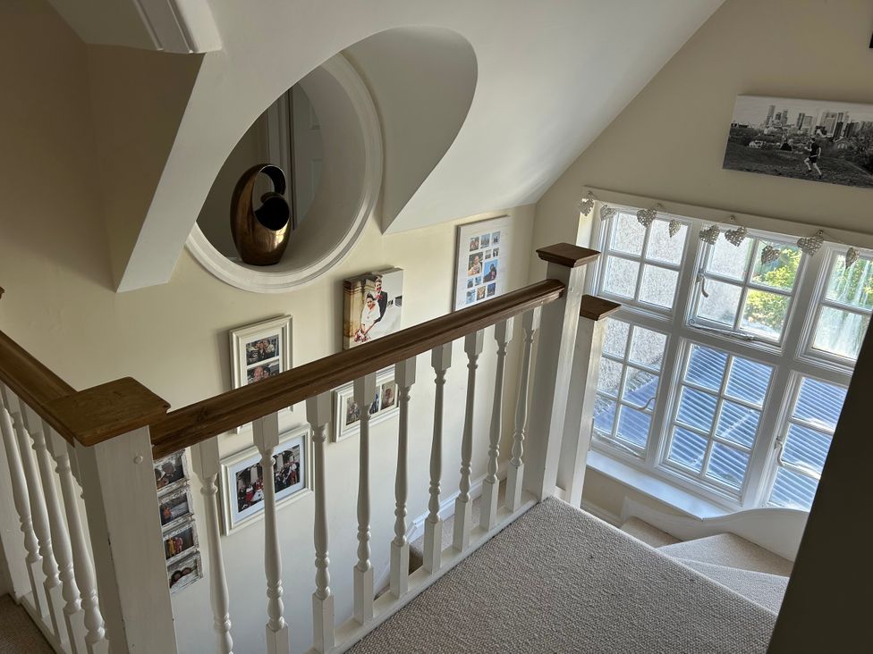 A staircase with a railing and photo frames at Somerby in St. Bees