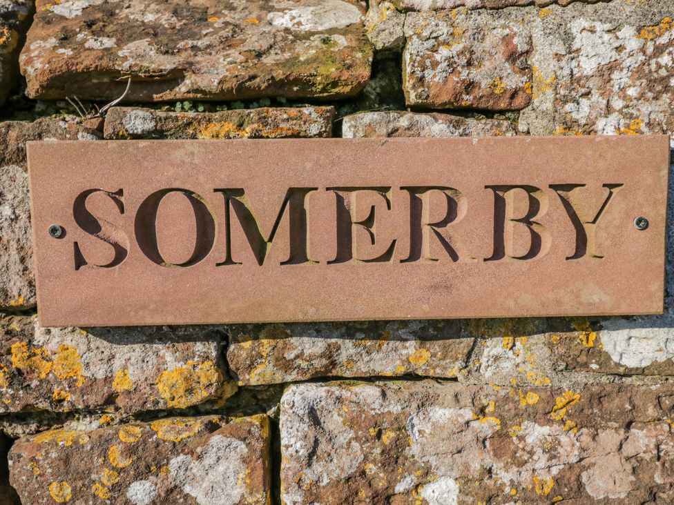 A nameplate reading 'SOMERBY' on a stone wall at Somerby St Bees