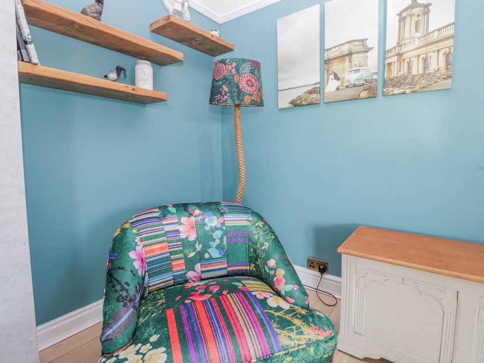 A living room with a chair and lamp at Somerby St Bees