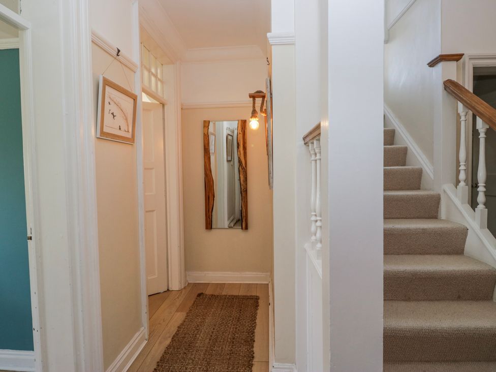 A hallway with a mirror and staircase at Somerby St Bees