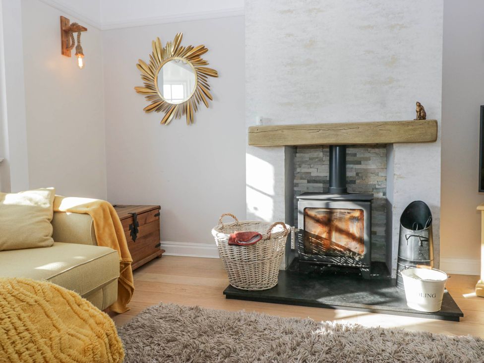 A living room with a fireplace and a sofa at Somerby in St Bees