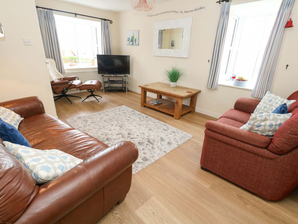 A living room with a sofa and television at Still Waters in Weymouth