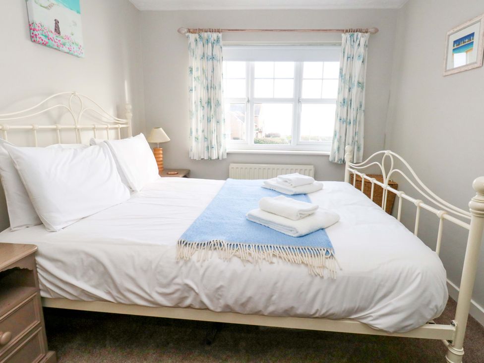 A bedroom with a bed and towels on it at Still Waters in Weymouth