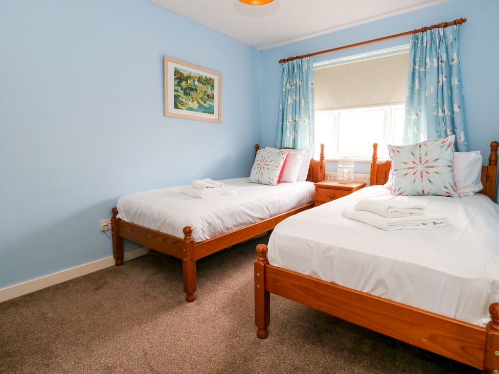 A bedroom with two beds and a window at Still Waters in Weymouth
