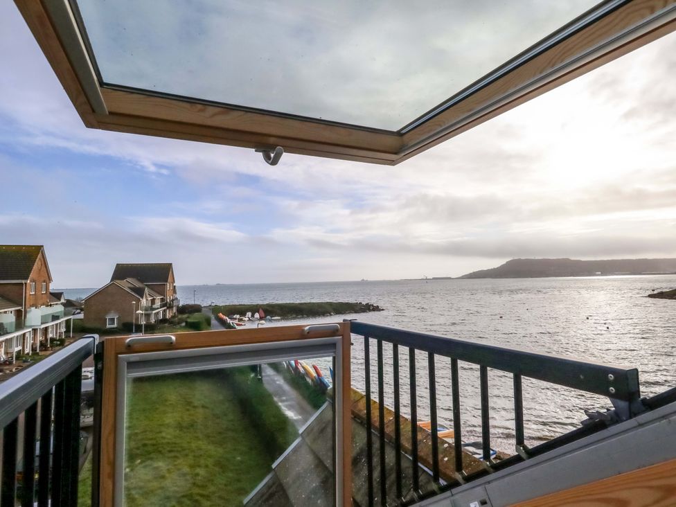 A view from a balcony overlooking water and houses at Still Waters in Weymouth