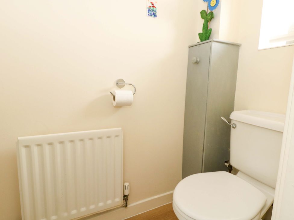A bathroom with a toilet and storage cabinet at Still Waters in Weymouth