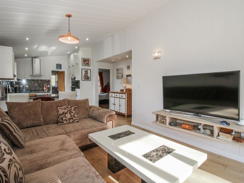 A living room with a sofa and television at Hazel Lodge in Clunton near Clun