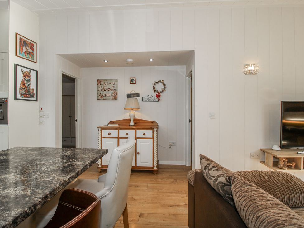 A living room with a cabinet and a television at Hazel Lodge Clunton near Clun