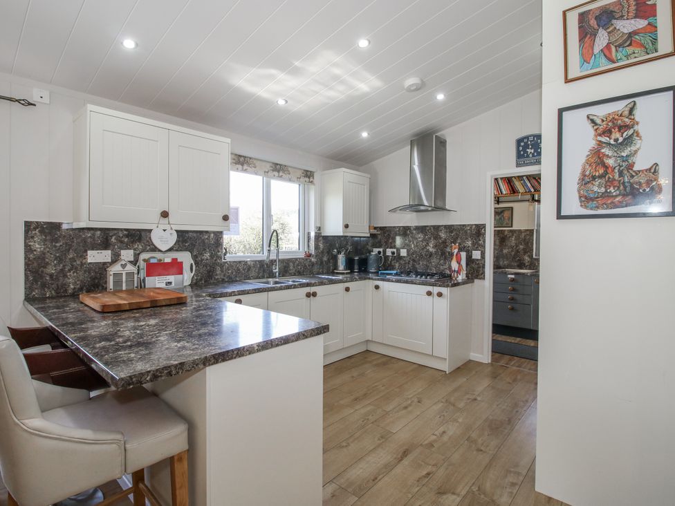 A kitchen with cabinets and a sink at Hazel Lodge in Clunton near Clun