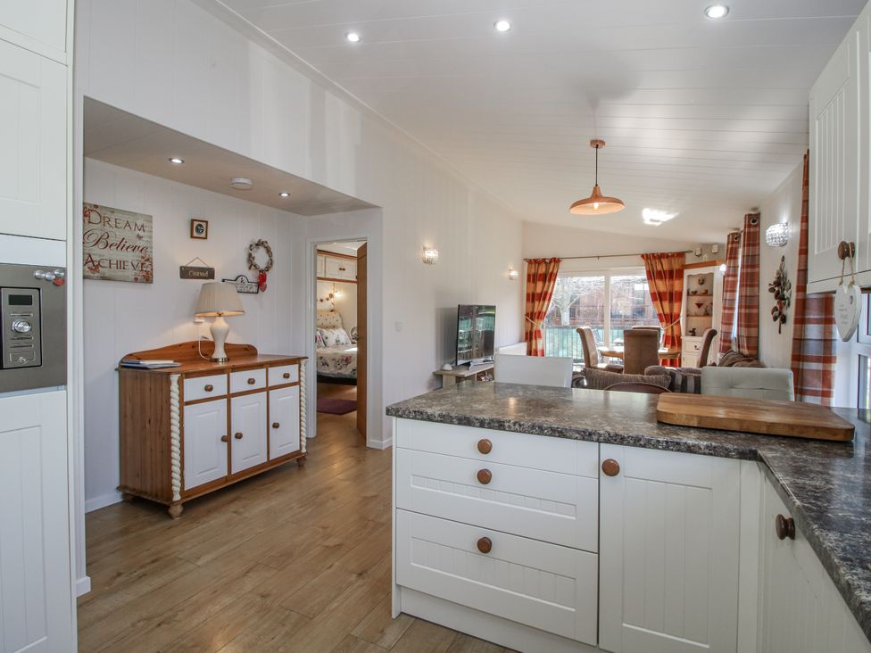 A kitchen with a console table and television at Hazel Lodge Clunton near Clun