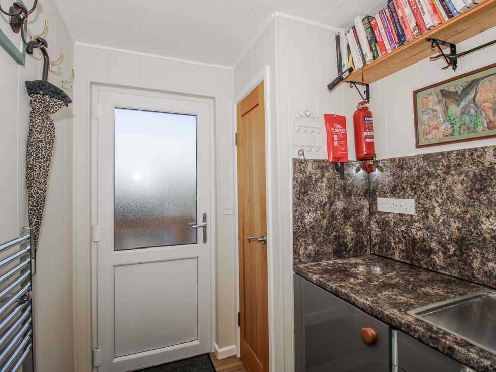 A kitchen with a door and countertop at Hazel Lodge in Clunton near Clun