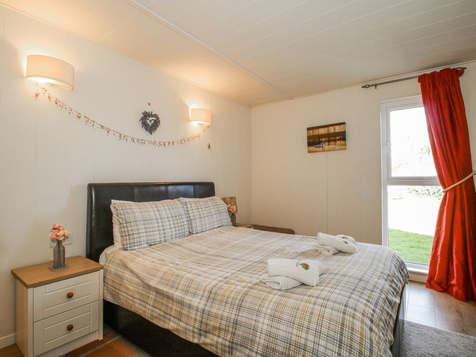 A bedroom with a bed and nightstand at Hazel Lodge in Clunton near Clun