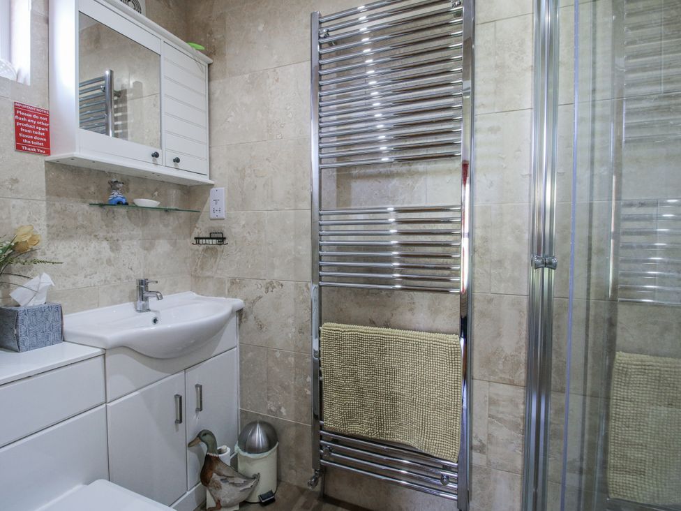 A bathroom with a sink and towel radiator at Hazel Lodge in Clunton near Clun