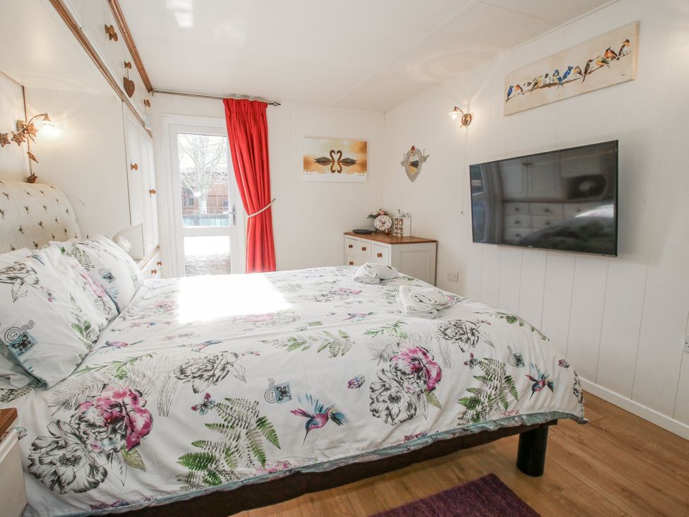 A bedroom with a bed and television at Hazel Lodge Clunton near Clun