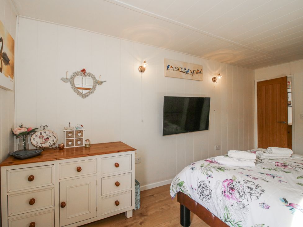 A bedroom with a bed and television at Hazel Lodge in Clunton near Clun