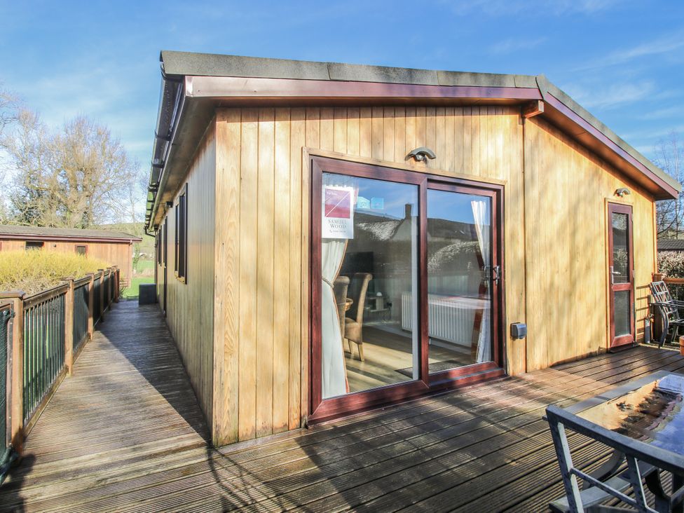 A wooden lodge with decking at Hazel Lodge in Clunton near Clun