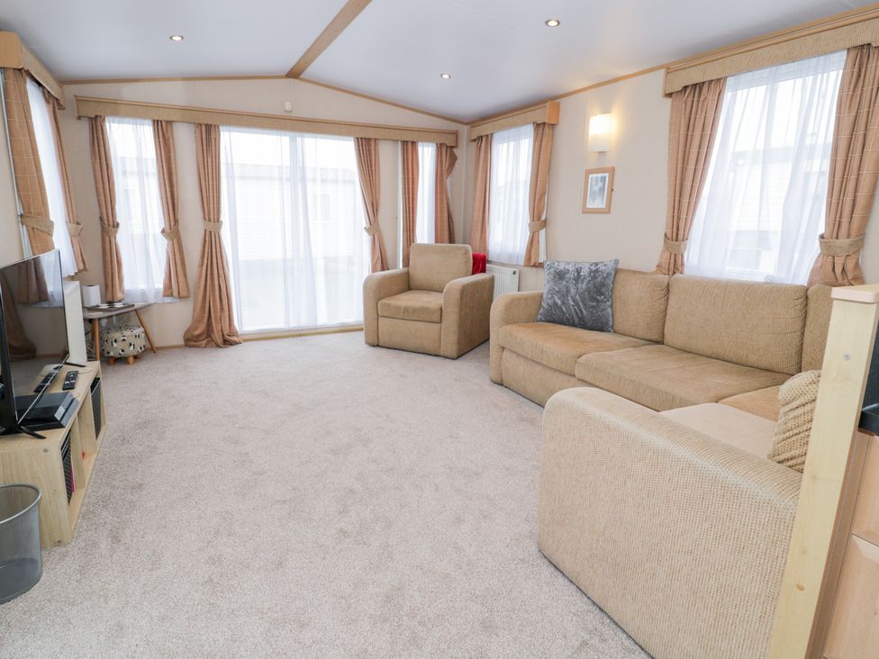 A living room with a sofa and armchair at 11, Beachfields