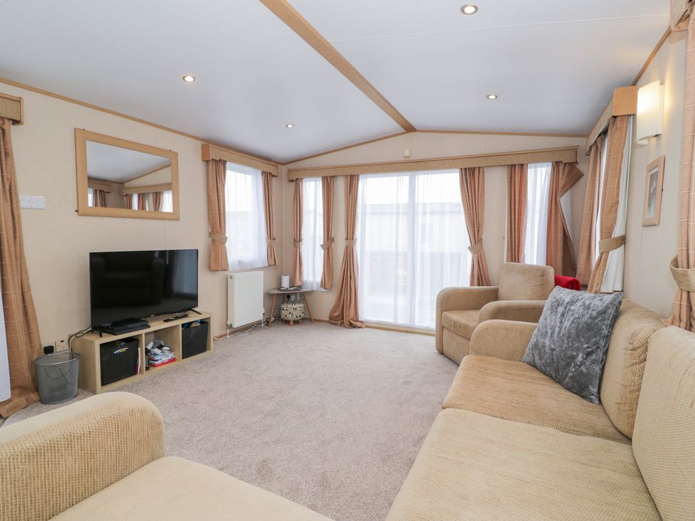 A living room with a television and sofa at 11, Beachfields