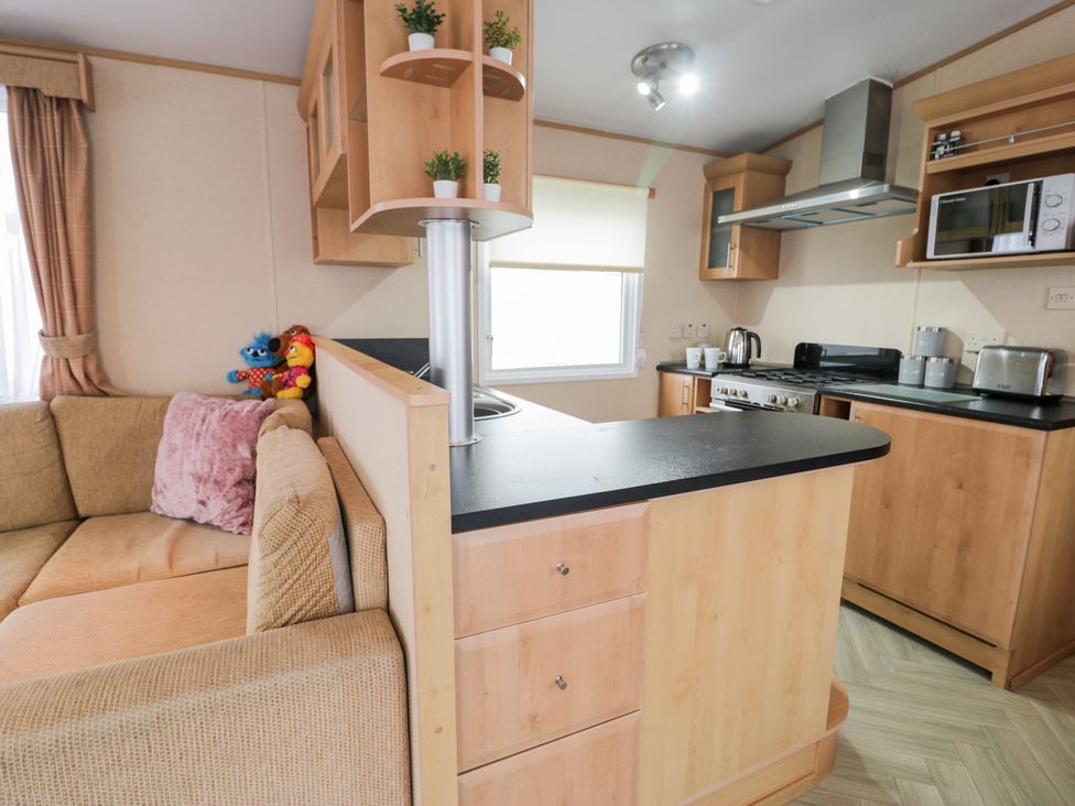 A kitchen with a sofa and appliances at 11, Beachfields