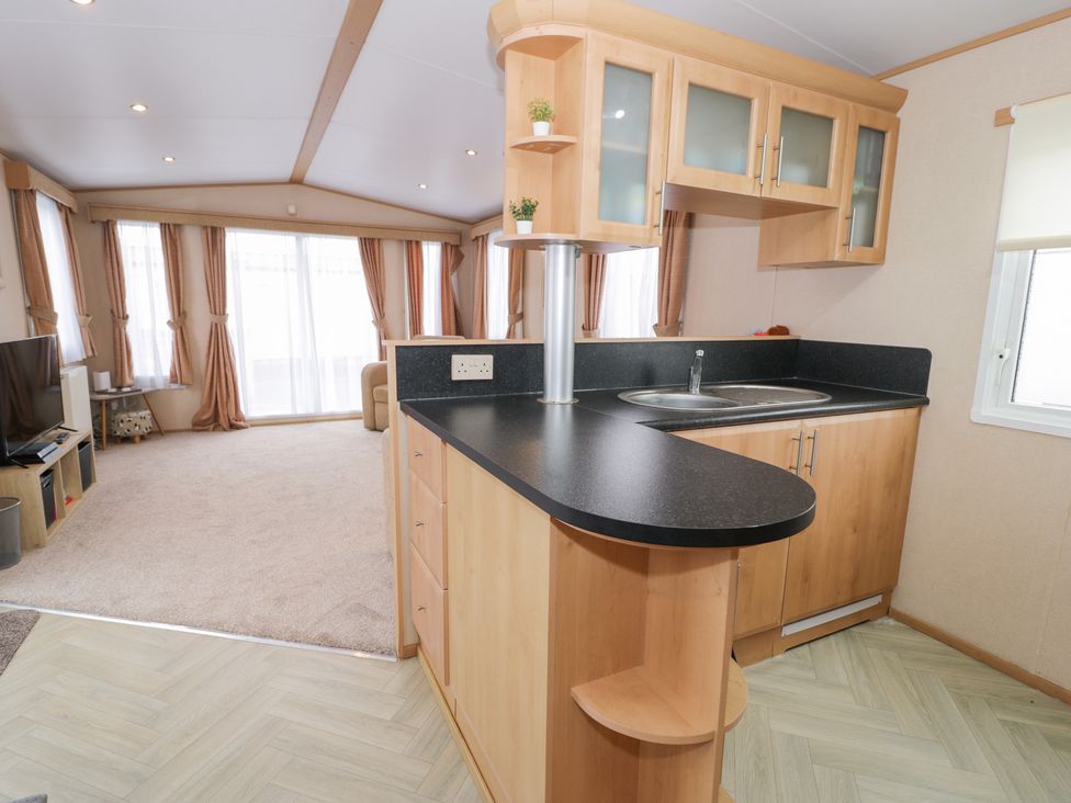 A kitchen area with cabinets and sink at 11, Beachfields