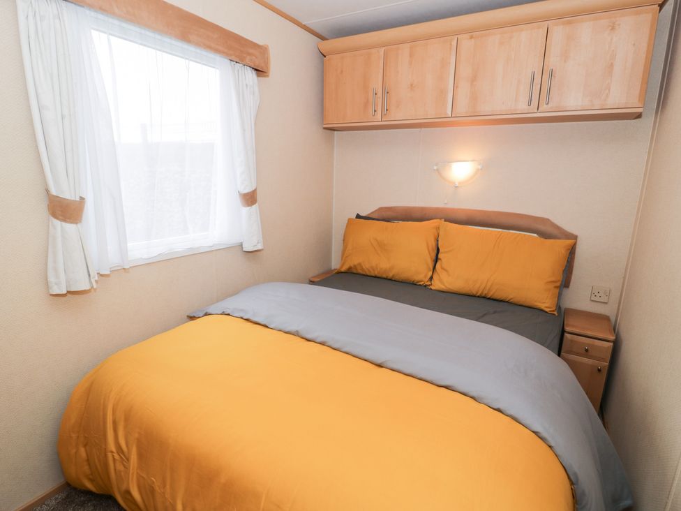 A bedroom with a bed and window at 11, Beachfields