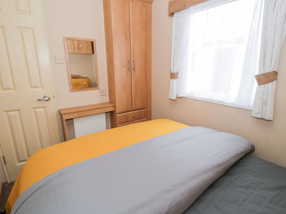 A bedroom with a bed and wardrobe at 11, Beachfields