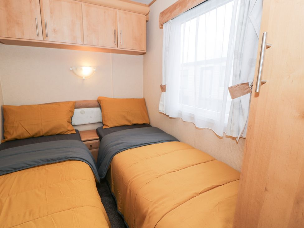 A bedroom with two beds and a window at 11, Beachfields