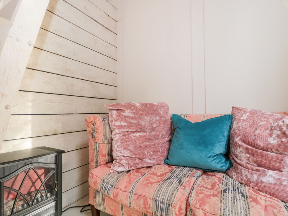 A sofa with cushions in a snug at Shades Farm Cabin in Cirencester